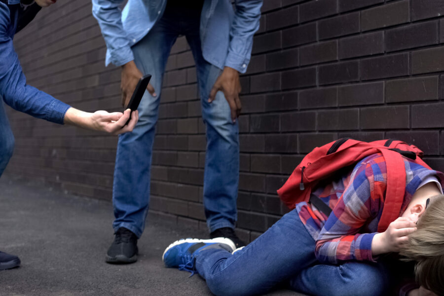 Junge mit Brille wird Opfer von mobbing und dabei gefilmt