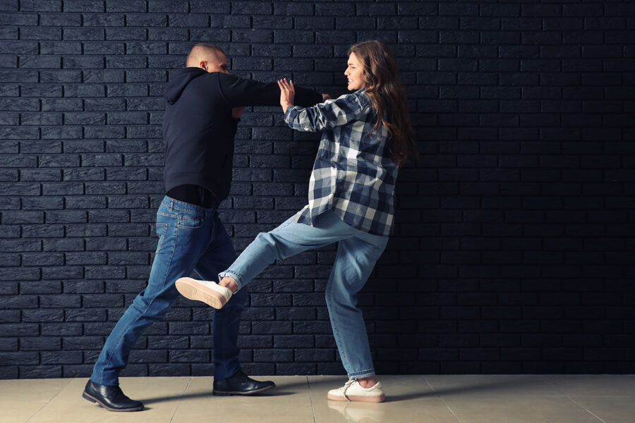 Eine Frau übt Selbstbehauptungstechniken gegen einen Angreifer