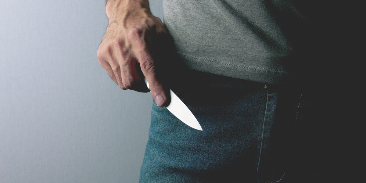 Messerattacke Ein Mann hält ein Messer in der rechten Hand und ist bereit dieses als Waffe zu benutzen